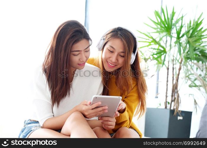 Young cute asia lesbian couple using tablet with happiness, lgbt, homosexual, lesbian couple lifestyle