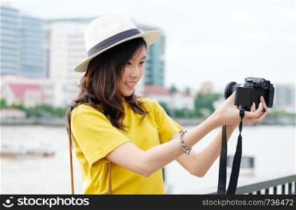 Young cute asian woman in casual style making selfie with camera in the urban city outdoors background, woman selfie, people outdoors with technology, travel and lifestyle concept