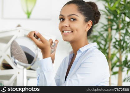 young cute beautiful woman putting on a perfume