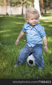 Young Cute Boy Playing with Soccer Ball in the Park.