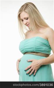 Young cute pregnant girl twenty five European-type. Portrait of a pregnant woman is looking at the stomach