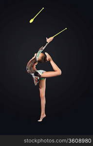 Young cute woman in gymnast suit show athletic skill on black background