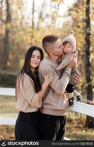 young dad and mom with baby girl walking in autumn park on sunny day. happy family concept. mother&rsquo;s, father&rsquo;s, baby&rsquo;s day. young dad and mom with baby girl walking in autumn park on sunny day. happy family concept. mother&rsquo;s, father&rsquo;s, baby&rsquo;s day.