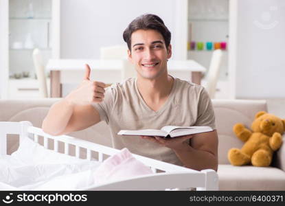 Young dad student preparing for exams and looking after baby