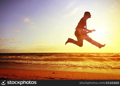 Young dancer. Silhouette of dancer jumping against city in lights of sunrise