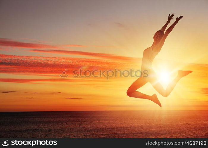 Young dancer. Silhouette of dancer jumping against city in lights of sunrise