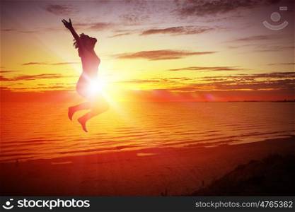 Young dancer. Silhouette of dancer jumping against city in lights of sunrise