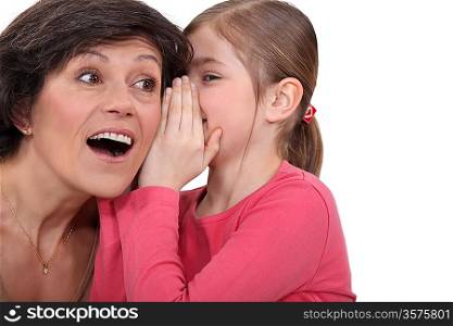 young daughter sharing secret with mom