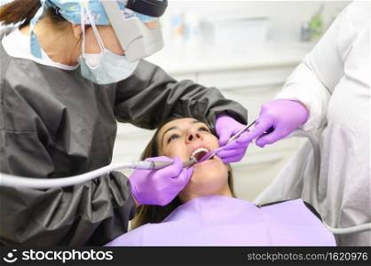 Young dentist working with female patient in a modern hospital. High quality photo. Young dentist working with female patient in a modern hospital.