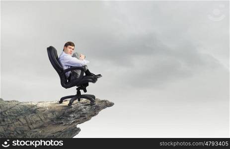 Young depressed businessman sitting in chair isolated from world. Leave me alone