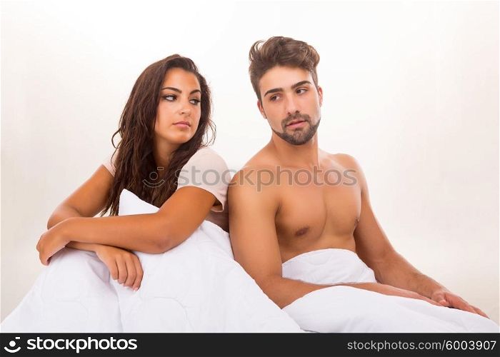 Young depressed couple in bed - daylife problems concept