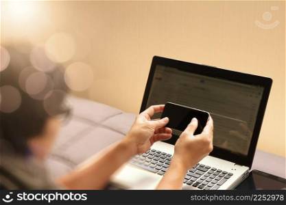  young designer working with blank screen smart phone and computer in bed as concept