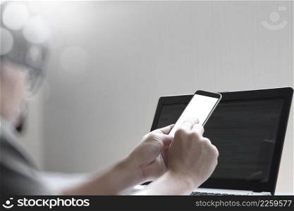 young designer working with blank screen smart phone and computer in bed as concept