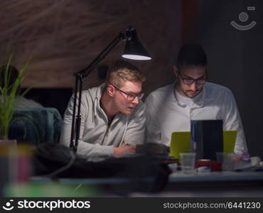 young designers working on a new project in the night startup office using modern technology