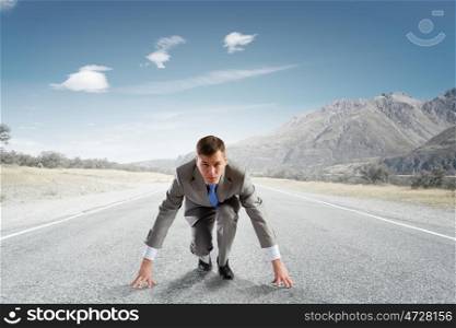 Young determined businessman standing in start position
