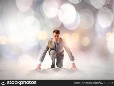 Young determined businessman standing in start position
