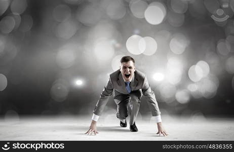 Young determined businessman standing in start position