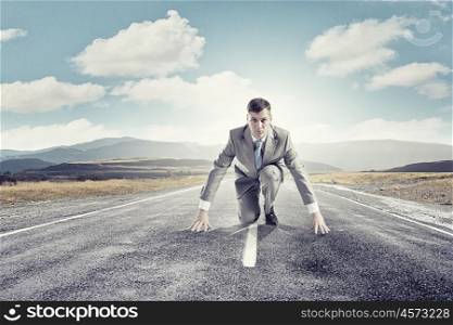 Young determined businessman standing in start position. Ready to challenge it