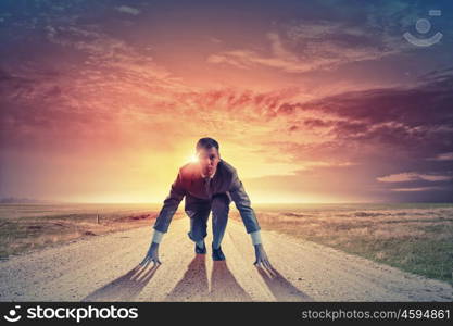 Young determined businessman standing in start position. Ready to challenge it