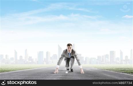Young determined businessman standing in start position. Ready to challenge it