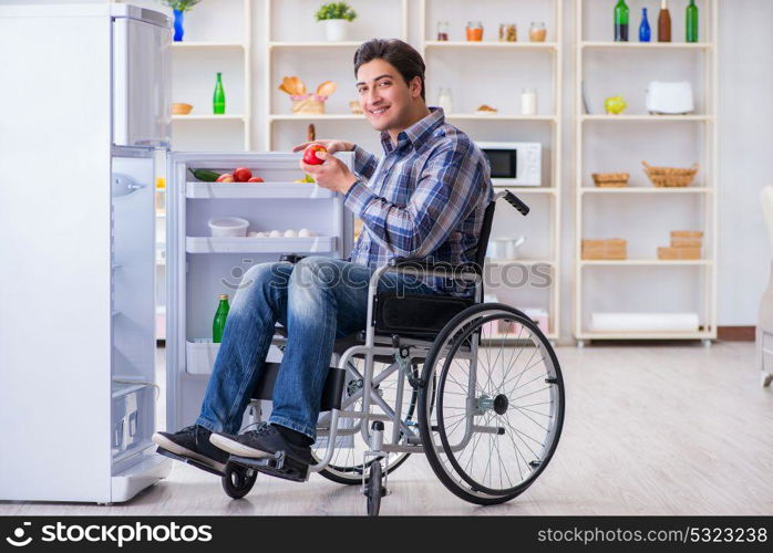 Young disabled injured man opening the fridge door