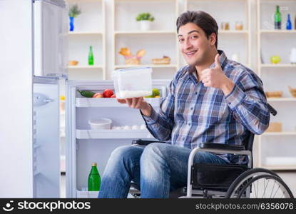 Young disabled injured man opening the fridge door