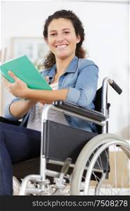 young disabled woman in wheelchair with book