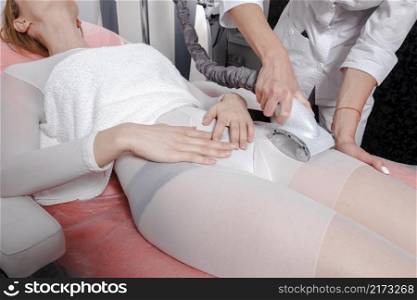 Young doctor applying lipo massage on girls body in beauty salon. Close up view. Lipo massage