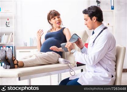 Young doctor checking pregnant woman&rsquo;s blood pressure. The young doctor checking pregnant woman&rsquo;s blood pressure