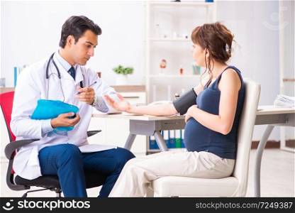 Young doctor checking pregnant woman’s blood pressure