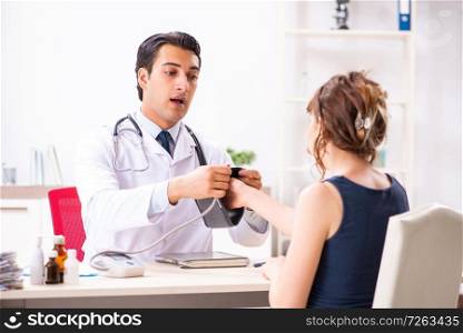 Young doctor checking woman’s blood pressure. The young doctor checking woman’s blood pressure