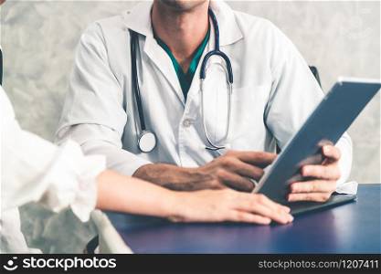 Young doctor examining female patient in hospital office. Medical healthcare and doctor staff service concept.. Young doctor examining patient in hospital office.