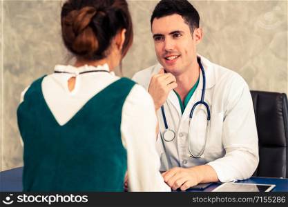 Young doctor examining female patient in hospital office. Medical healthcare and doctor staff service concept.