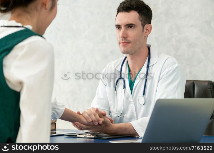 Young doctor examining female patient in hospital office. Medical healthcare and doctor staff service concept.