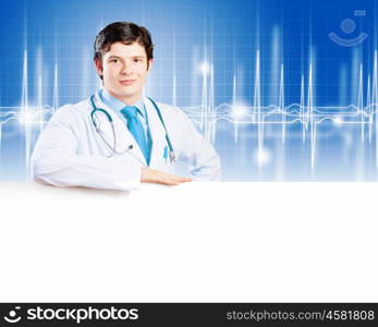 Young doctor. Image of handsome doctor holding white blank banner