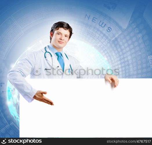 Young doctor. Image of handsome doctor holding white blank banner