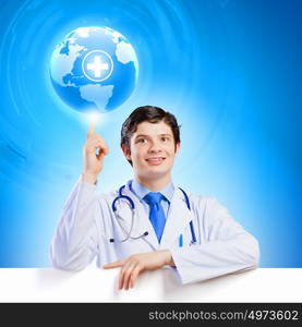 Young doctor. Image of handsome doctor holding white blank banner