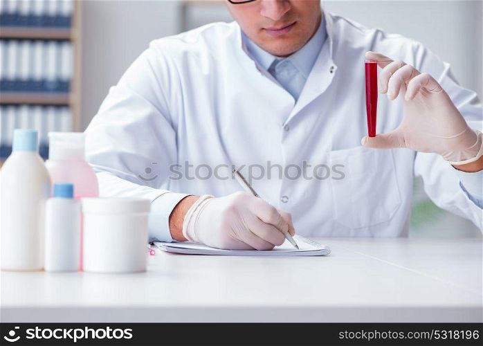 Young doctor in the lab with red tube