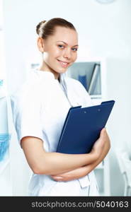 Young doctor in white uniform standing and holding papers