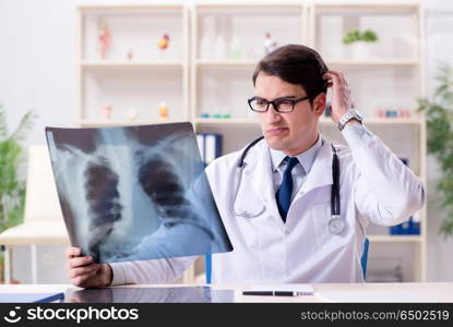 Young doctor looking at x-ray images in clinic