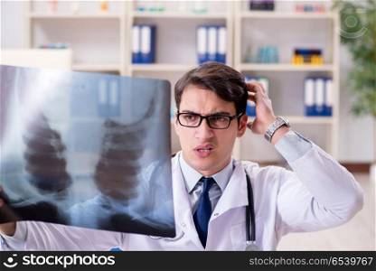 Young doctor looking at x-ray images in clinic