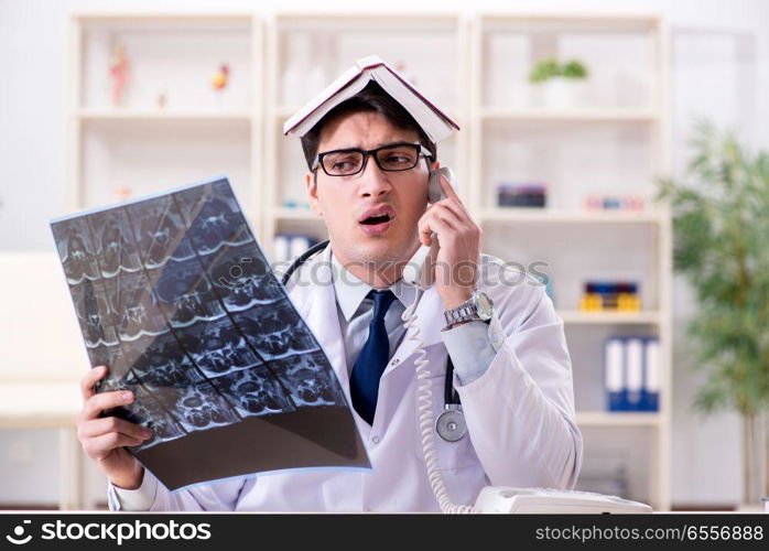 Young doctor looking at x-ray images in clinic