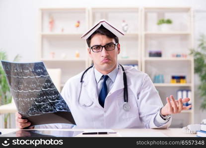 Young doctor looking at x-ray images in clinic