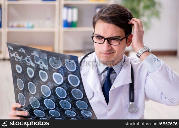 Young doctor looking at x-ray images in clinic