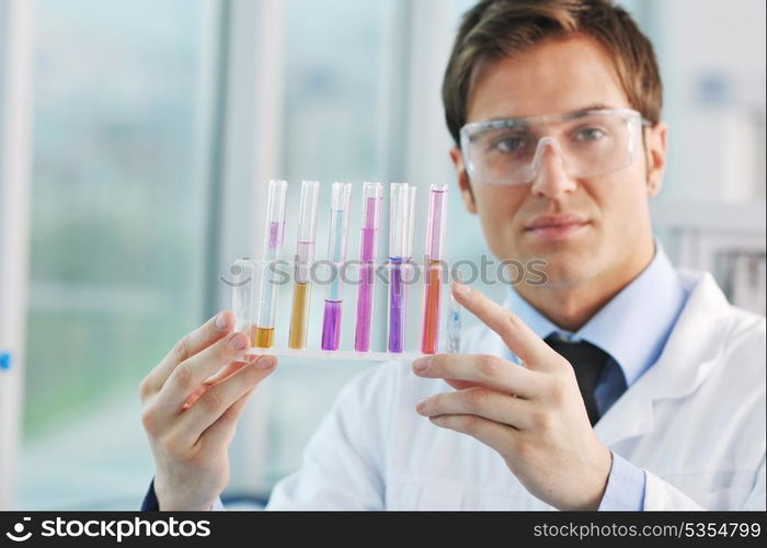 young doctor scientist in bright labaratory work research and analyse content of test tubes representing chemistry and research concept