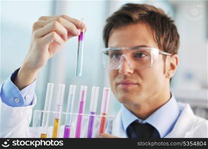 young doctor scientist in bright labaratory work research and analyse content of test tubes representing chemistry and research concept