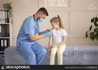 young doctor vaccinating little girl