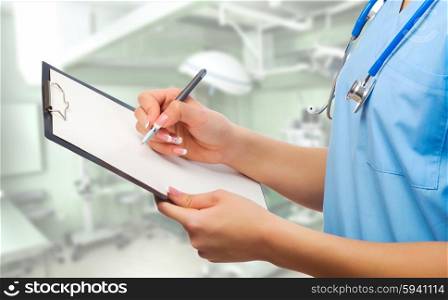 Young doctor with clipboard on medical office