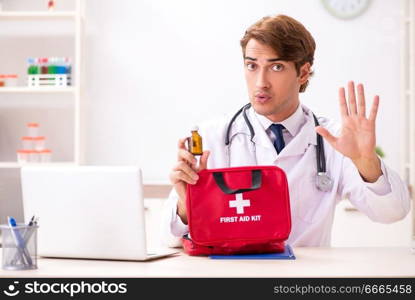 Young doctor with first aid kit in hospital. The young doctor with first aid kit in hospital