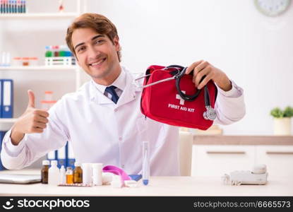 Young doctor with first aid kit in hospital. The young doctor with first aid kit in hospital